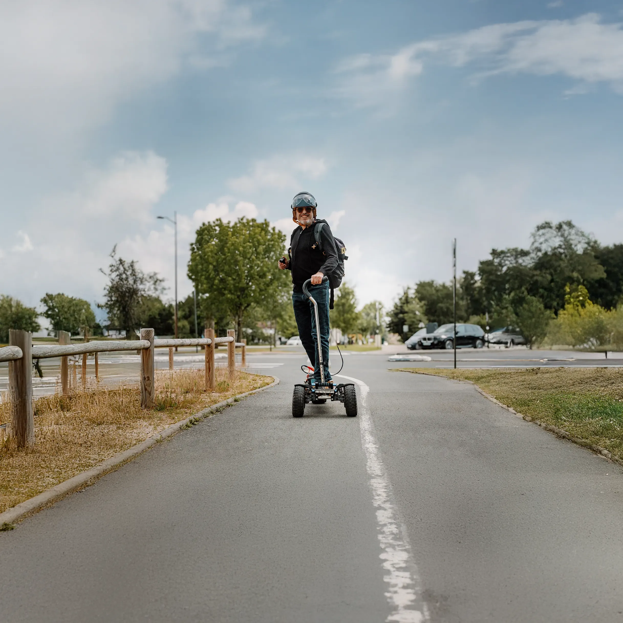 Rider senior sonriente sobre Sternboard eléctrico todo terreno, demostración de facilidad de uso y accesibilidad multigeneracional para principiantes en deportes de deslizamiento